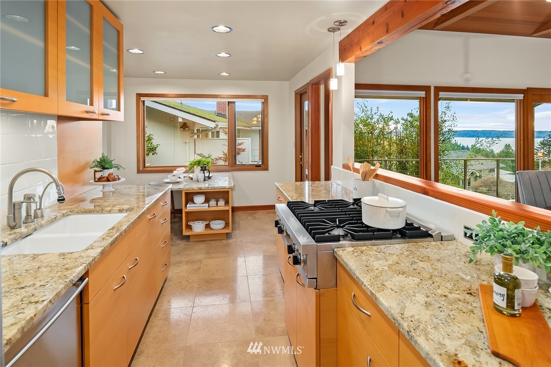 8560 Fauntlee Crest Southwest Seattle, WA 98136 - Photo 10 of 30 a kitchen with stainless steel appliances granite countertop sink stove and granite counter top