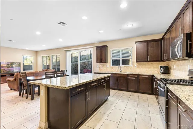 a kitchen with stainless steel appliances granite countertop a sink and a stove