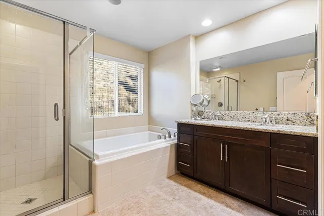 a bathroom with a bathtub sink double vanity and mirror