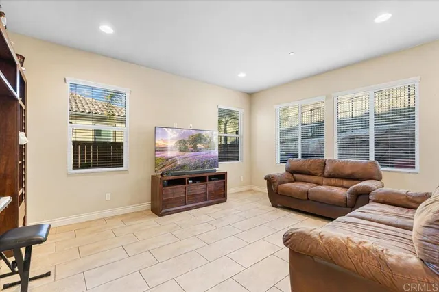 a living room with furniture a flat screen tv and a large window