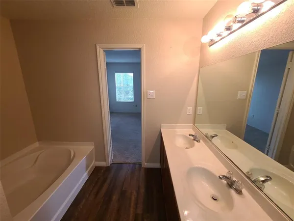 a bathroom with a tub sink and mirror