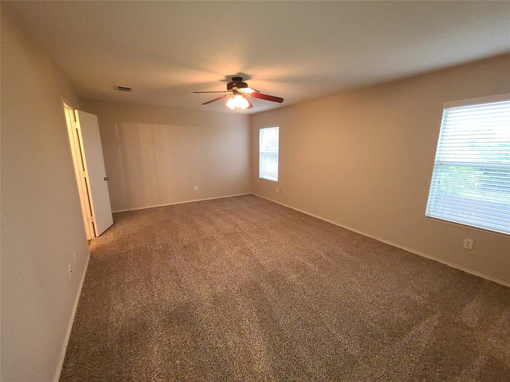 12141 Shine Avenue Rhome, TX 76078 - Photo 20 of 40 an empty room with windows and chandelier fan