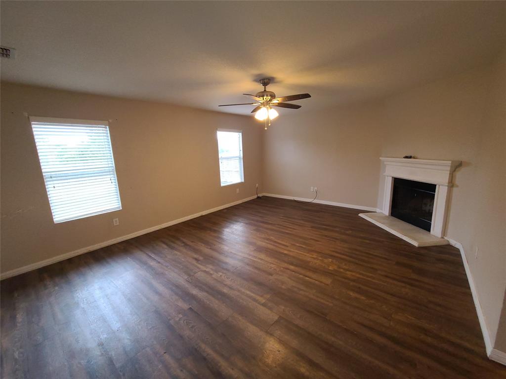 12141 Shine Avenue Rhome, TX 76078 - Photo 2 of 40 a view of an empty room with wooden floor and a window