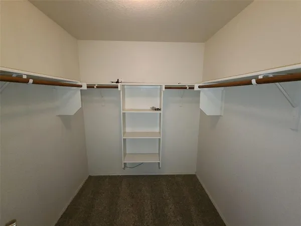 a view of walk in closet with empty racks