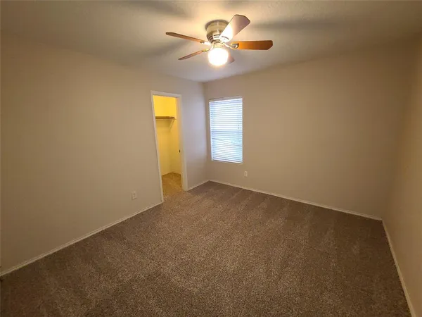 a view of a room with a ceiling fan and a window