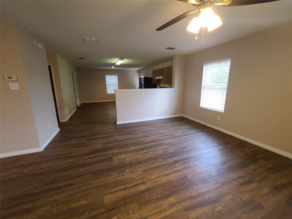 12141 Shine Avenue Rhome, TX 76078 - Photo 4 of 40 an empty room with wooden floor and windows