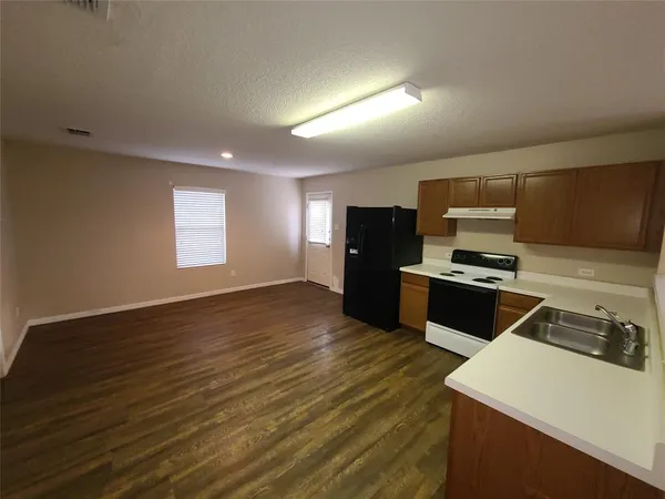 a kitchen with a refrigerator and a stove top oven