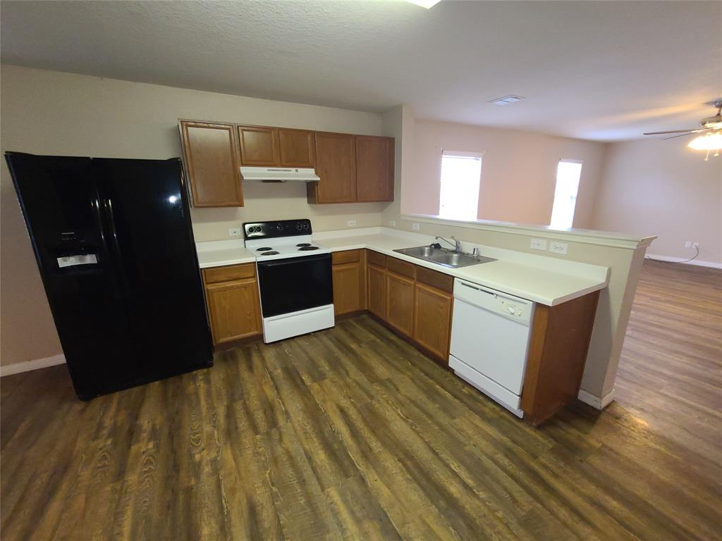12141 Shine Avenue Rhome, TX 76078 - Photo 10 of 40 a kitchen with stainless steel appliances granite countertop a stove a sink and a refrigerator