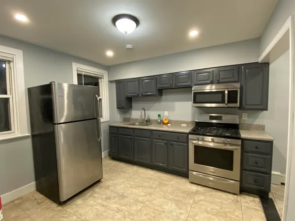 a kitchen with stainless steel appliances granite countertop a refrigerator stove and microwave