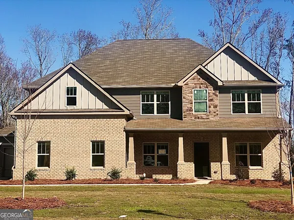 a front view of a house with a yard outdoor seating and garage