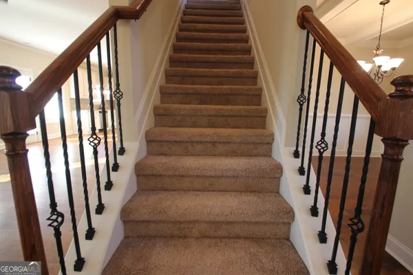 a view of staircase with lots of frames on wall