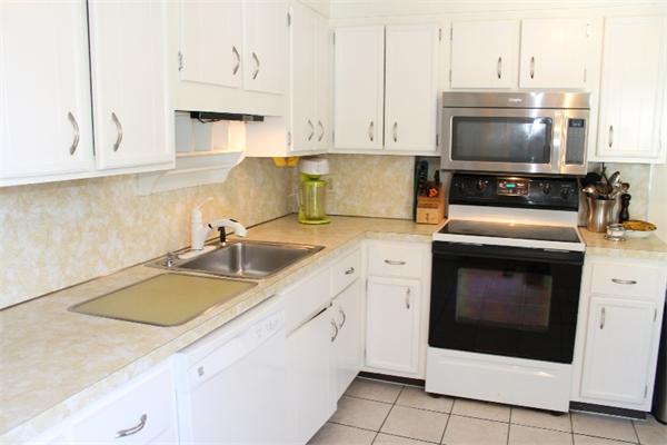 54 School Street Lexington, MA 02421 - Photo 9 of 16 a kitchen with granite countertop a sink stainless steel appliances and white cabinets