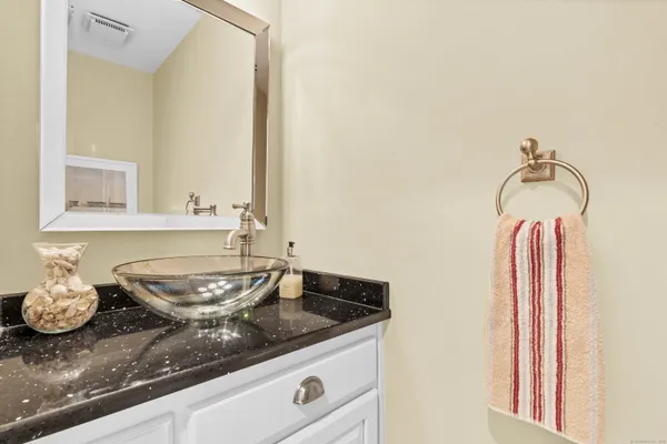 a bathroom with a granite countertop sink and a mirror