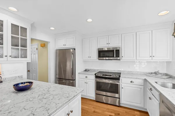 a kitchen with granite countertop a sink stove and refrigerator