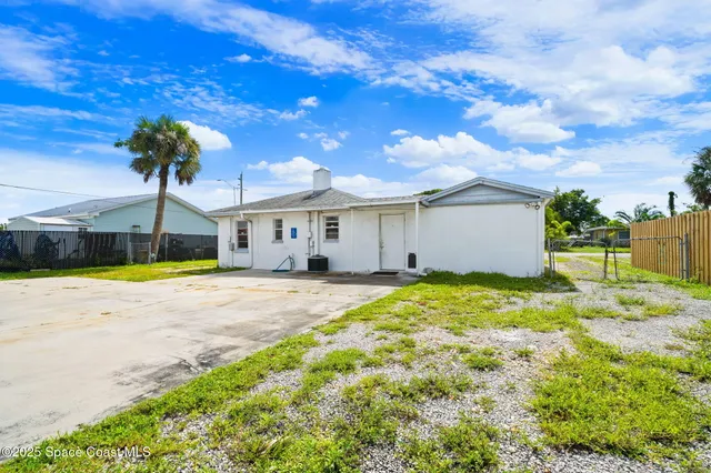 a view of a house with backyard and a tree
