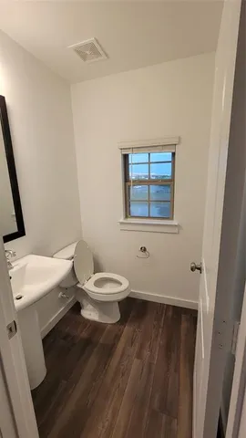 a bathroom with a toilet a sink and a window