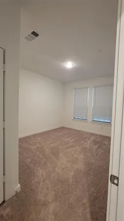 an empty room with closet and windows