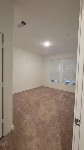 an empty room with closet and windows