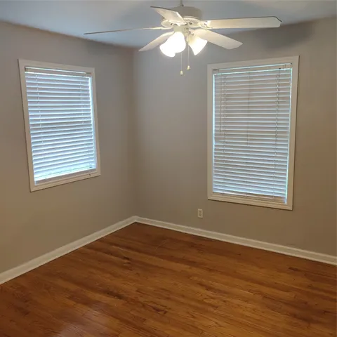 a view of a room with wooden floor and a window