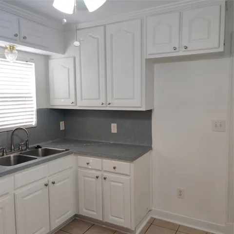 a kitchen with white cabinets and a sink