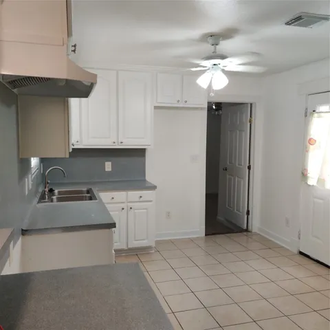 a kitchen with granite countertop white cabinets and stainless steel appliances