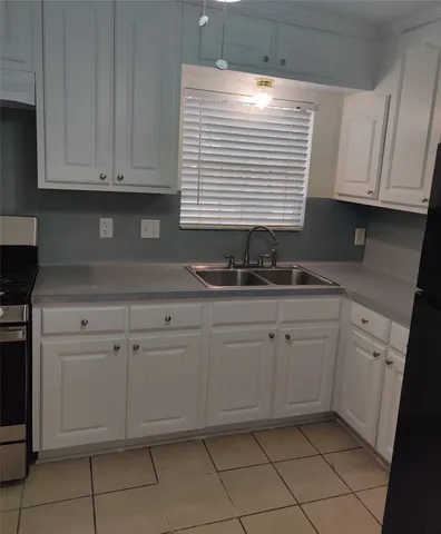 a kitchen with white cabinets a sink and dishwasher