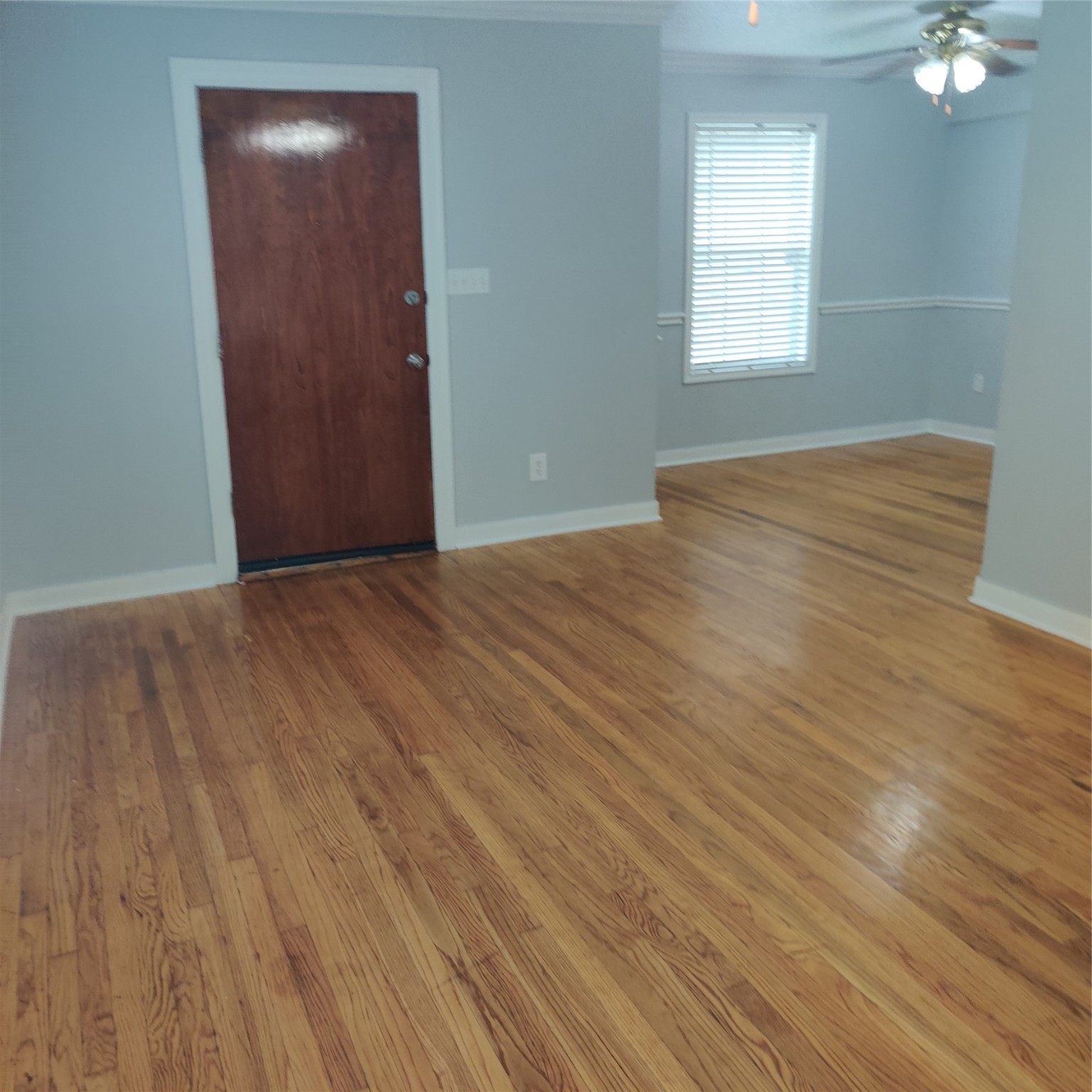 919 Oak Meadows Street Houston, TX 77017 - Photo 8 of 12 an empty room with wooden floor and windows with curtains