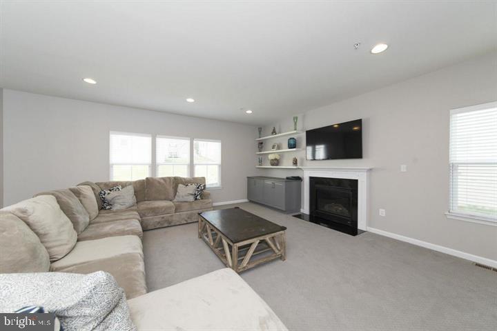10431 Windlass Run Road Baltimore, MD 21220 - Photo 13 of 30 a living room with furniture a fireplace and a flat screen tv