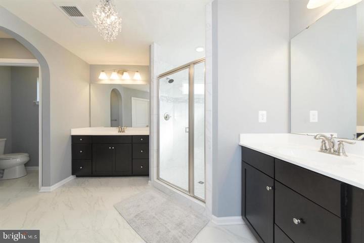 10431 Windlass Run Road Baltimore, MD 21220 - Photo 17 of 30 a spacious bathroom with a double vanity sink mirror and toilet