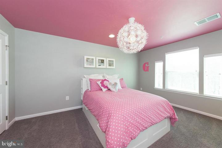 10431 Windlass Run Road Baltimore, MD 21220 - Photo 21 of 30 a bedroom with a bed chandelier and a window
