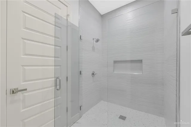 a bathroom with a shower and a glass door