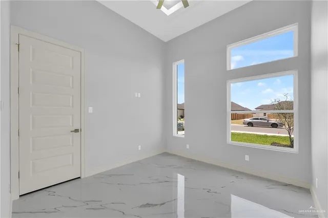 an empty room with window and a ceiling fan