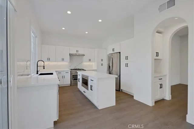a kitchen with stainless steel appliances a stove a refrigerator and cabinets