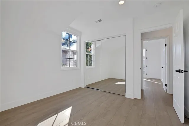 a spacious bathroom with double sink a mirror a window and a shower