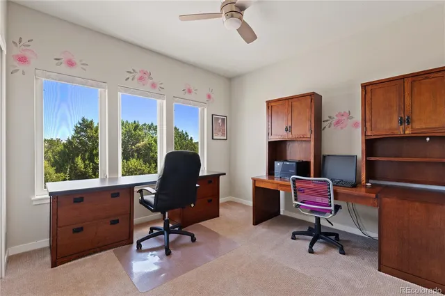 a view of a workspace with furniture and a window