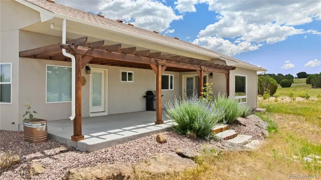 a view of a house with potted plants next to a road