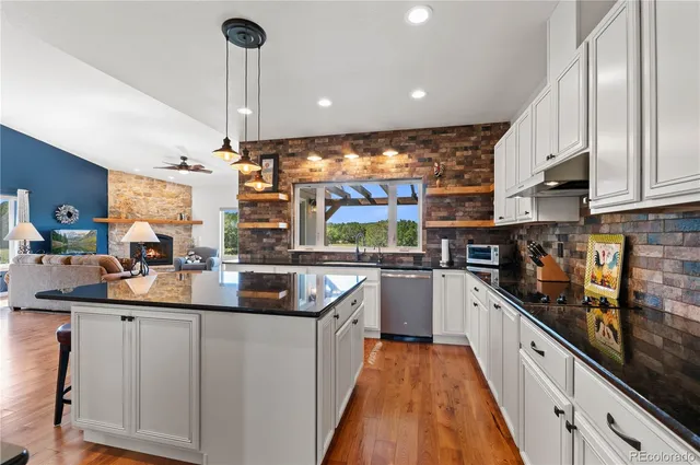 a kitchen with stainless steel appliances a sink a stove top oven a counter space and cabinets