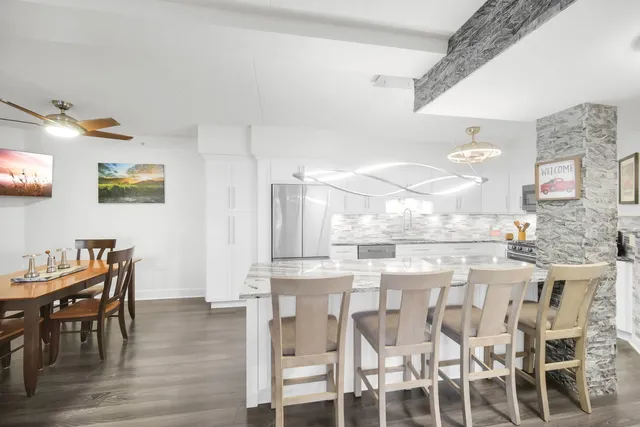 a kitchen with stainless steel appliances kitchen island granite countertop a table and chairs in it