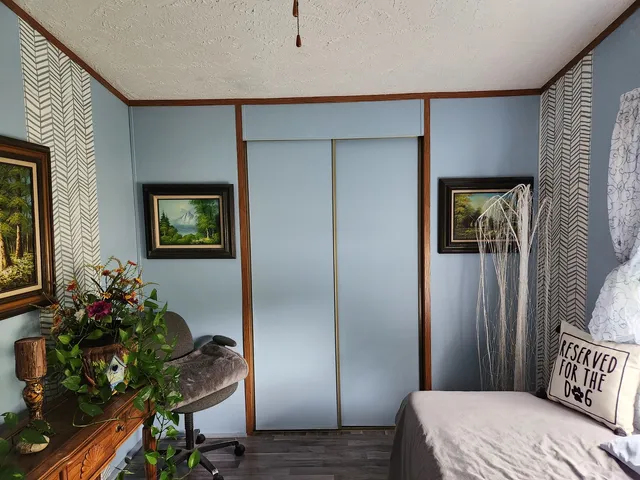 a view of a hallway with wooden floor and windows