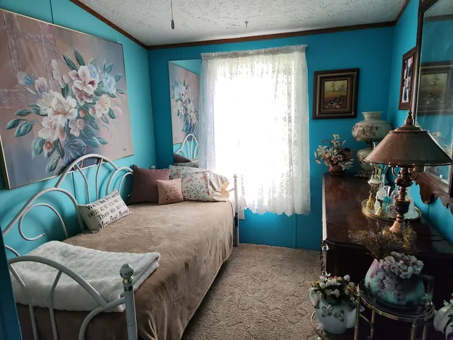 a bedroom with a bed and a lamp on the dresser