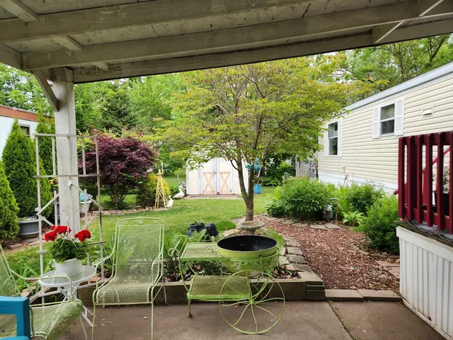 a view of backyard with seating space and green space