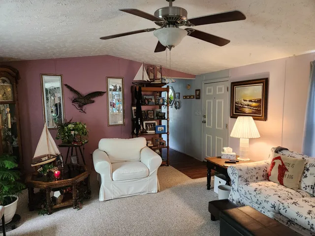 a living room with furniture a bookshelf and a window