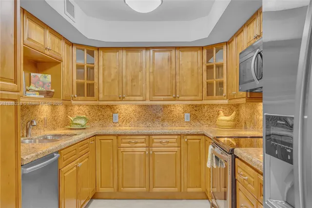 a view of a kitchen with stainless steel appliances granite countertop a sink and cabinets