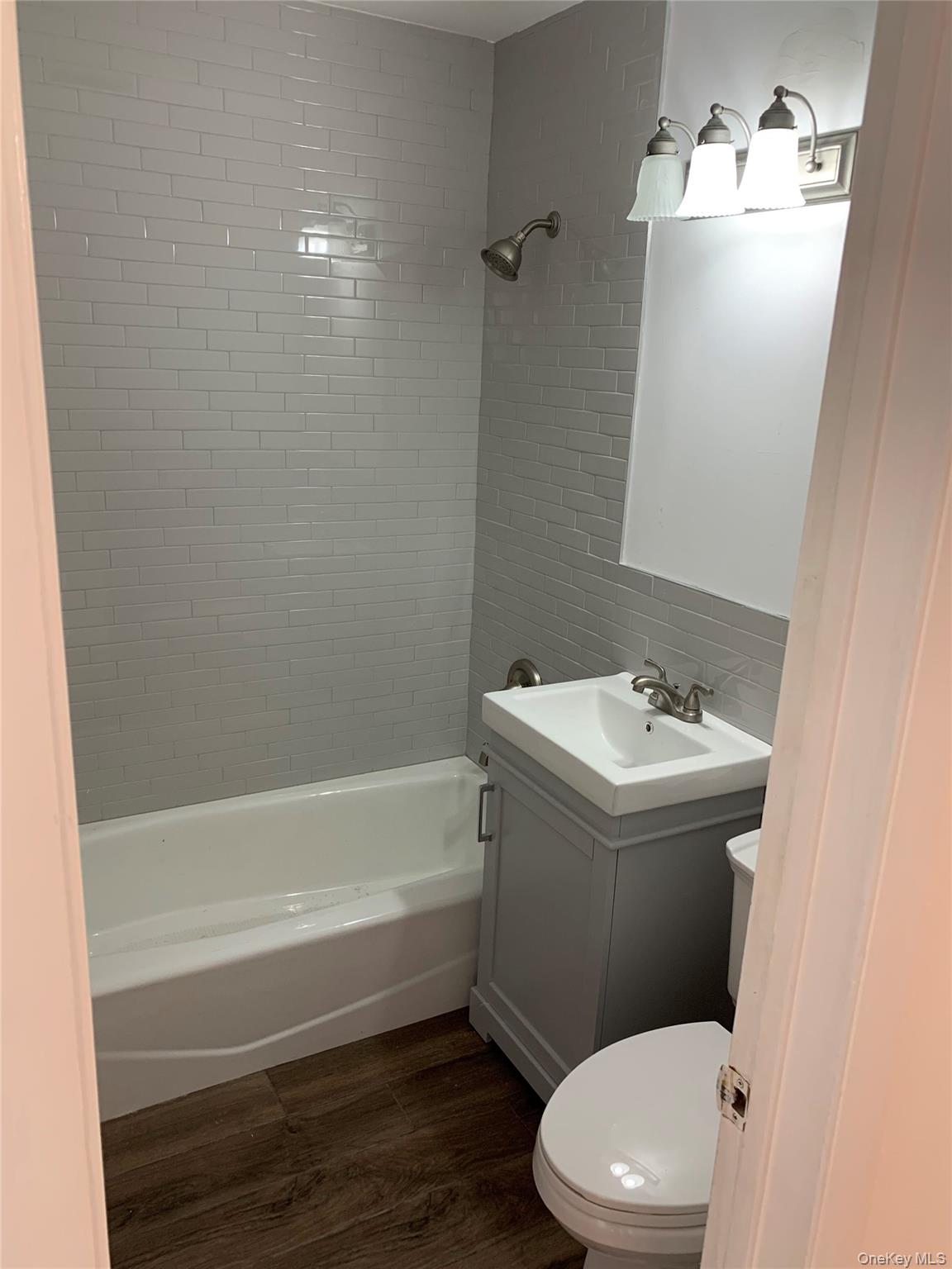 87 Sickles Avenue New Rochelle, NY 10801 - Photo 10 of 10 Full bathroom with dark wood-style floors, vanity, and tub / shower combination