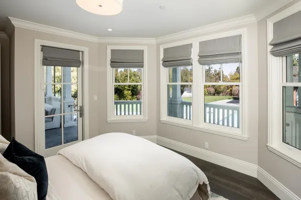 a view of a hallway with wooden floor and windows