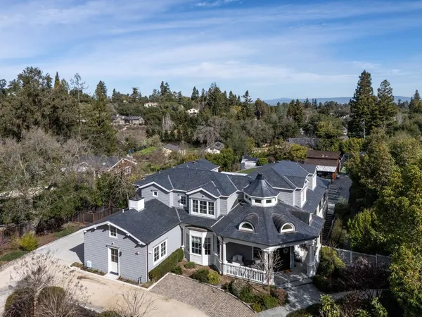 a view of a big house with a big yard and large trees