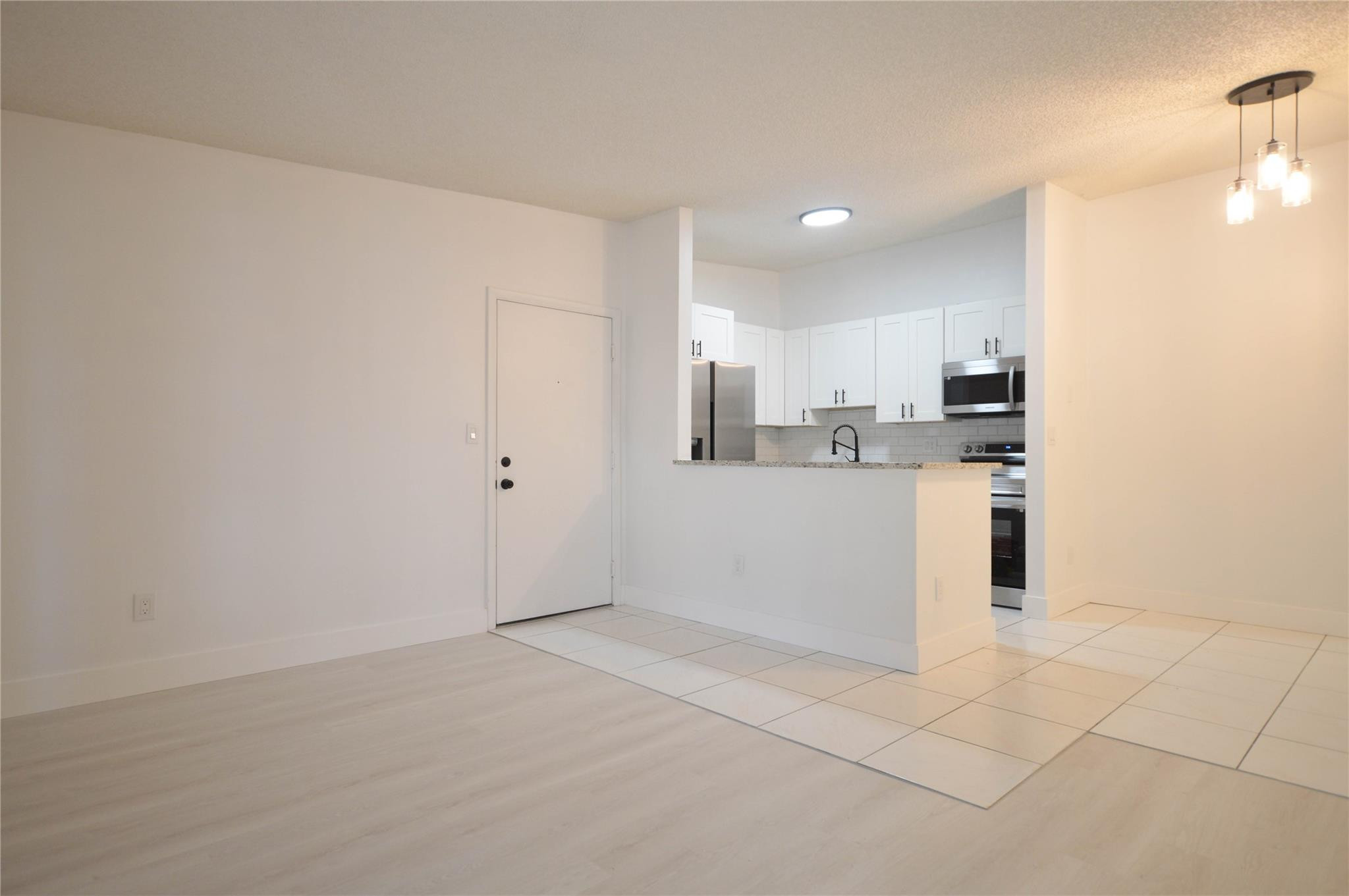 9499 West McNab Road, Unit 208 Tamarac, FL 33321 - Photo 2 of 19 a kitchen with white cabinets and white appliances