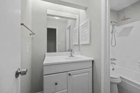 a bathroom with a sink toilet vanity and shower