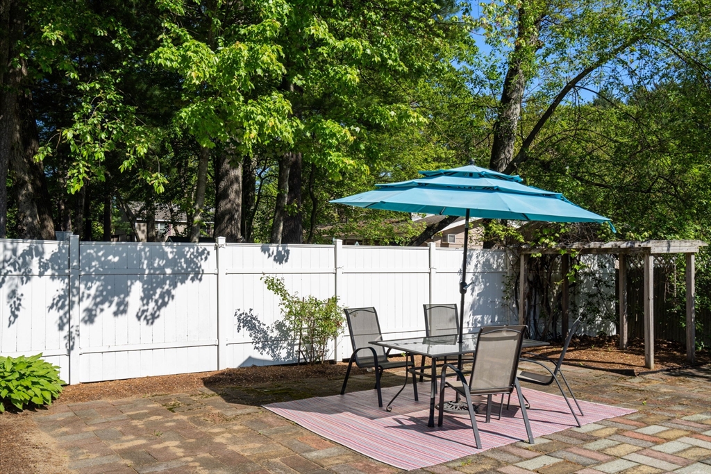3 Norman Road Billerica, MA 01821 - Photo 25 of 28 a patio with a table and chairs under an umbrella