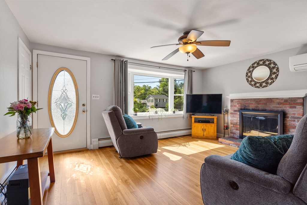 3 Norman Road Billerica, MA 01821 - Photo 6 of 28 a living room with furniture a fireplace a flat screen tv and a large window